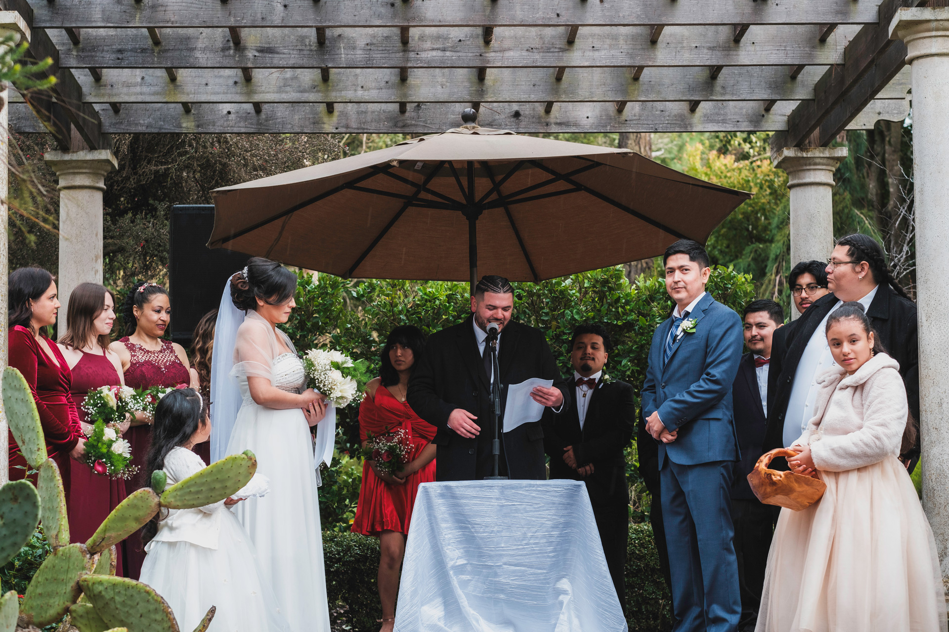 Karla and Birhon at their outdoor wedding ceremony, surrounded by their loved ones.