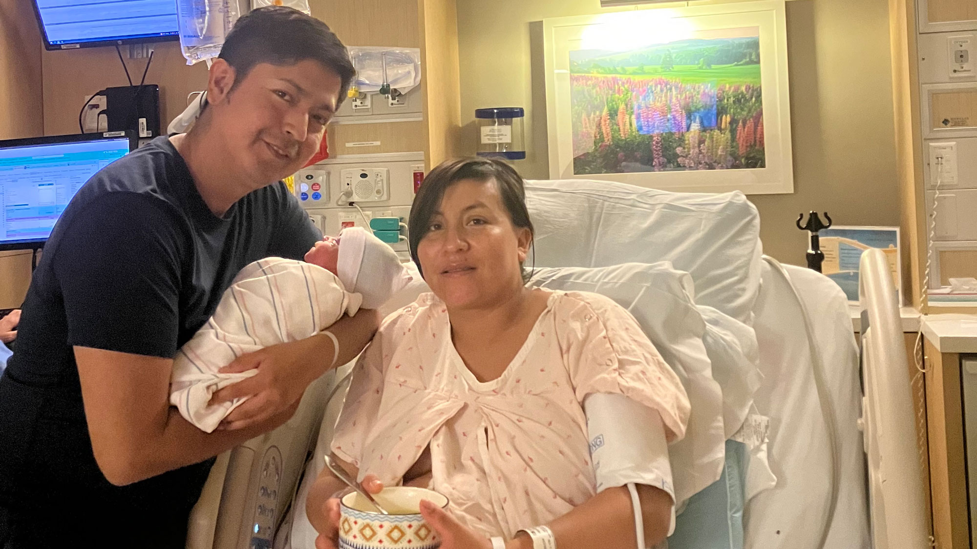 Birhon holding newborn Gael beside Karla in the hospital, their first moments together.