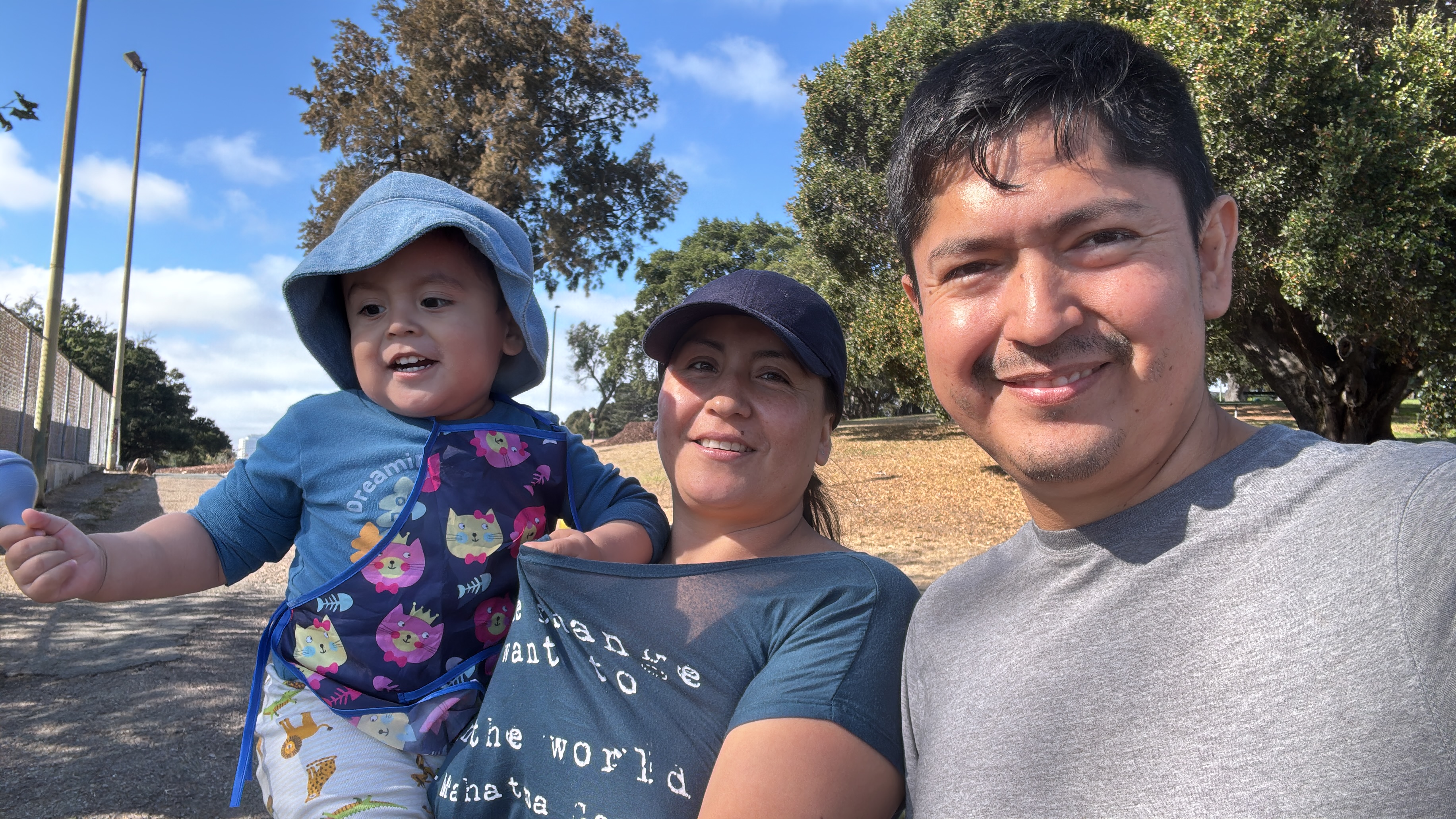 Birhon, Karla, and Gael smiling together outdoors on a sunny day.