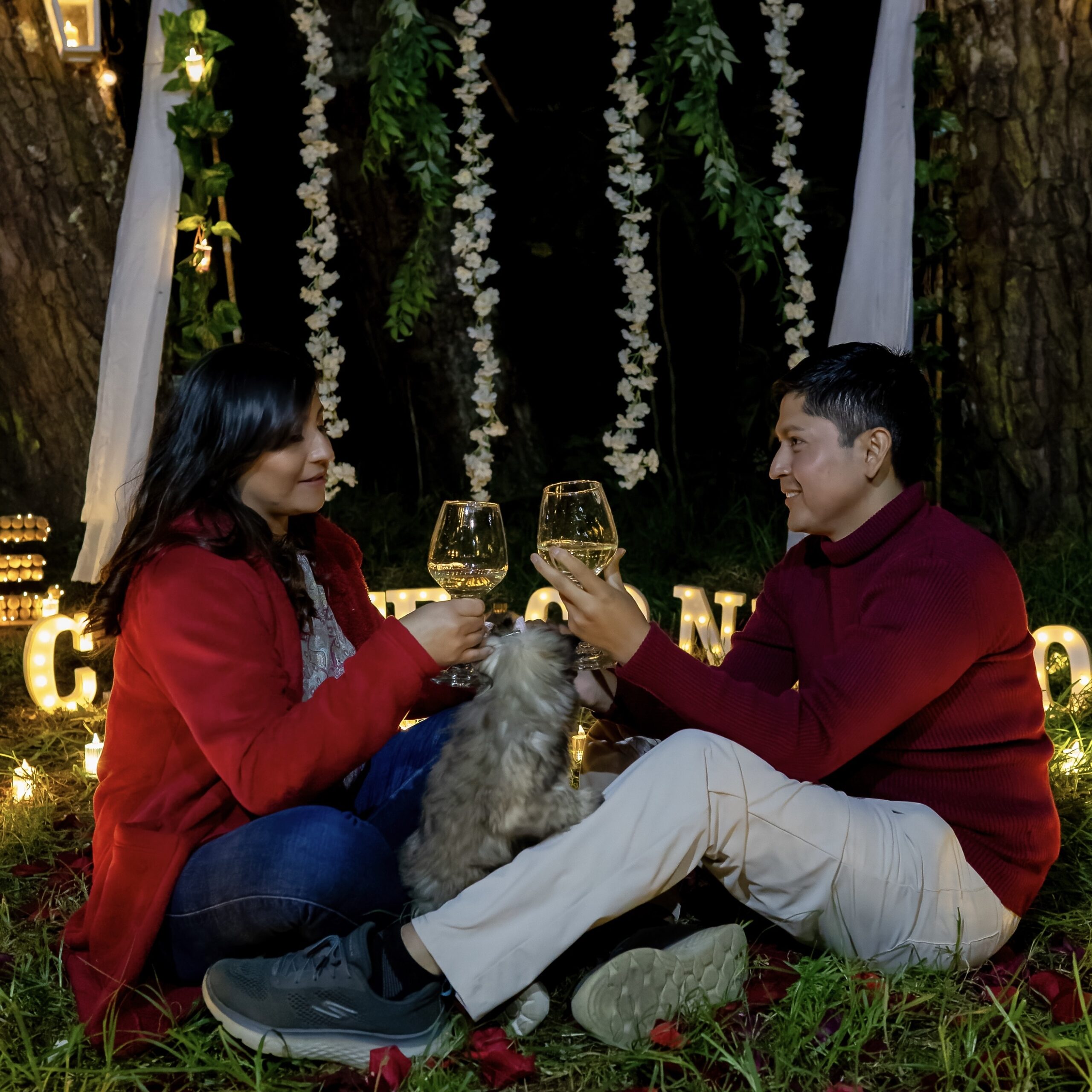 Karla and Birhon raising their glasses together outdoors.
